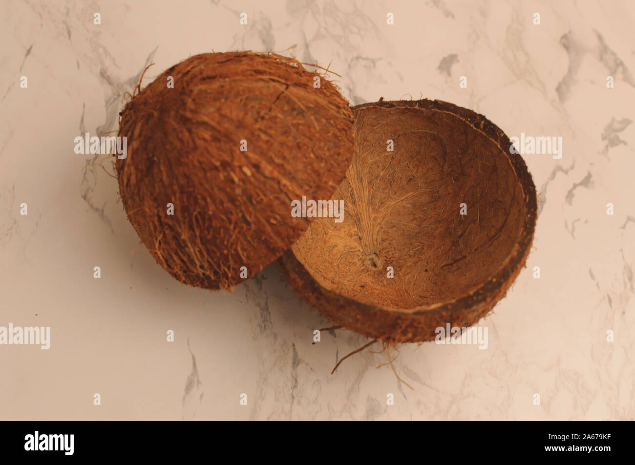 Deux moitiés d'une coquille de noix de coco sur un arrière-plan en marbre, d'isoler. Les bols de nourriture aucun déchet. Des matériaux respectueux de l'environnement pour les ustensiles. Copie Banque D'Images