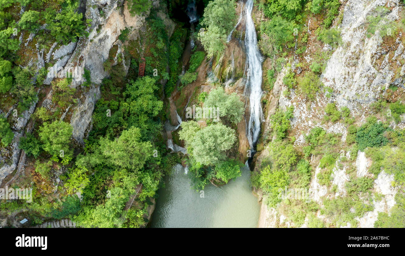 Vue de dessus d'une cascade dans la montagne entourée de verdure. Vue aérienne Banque D'Images