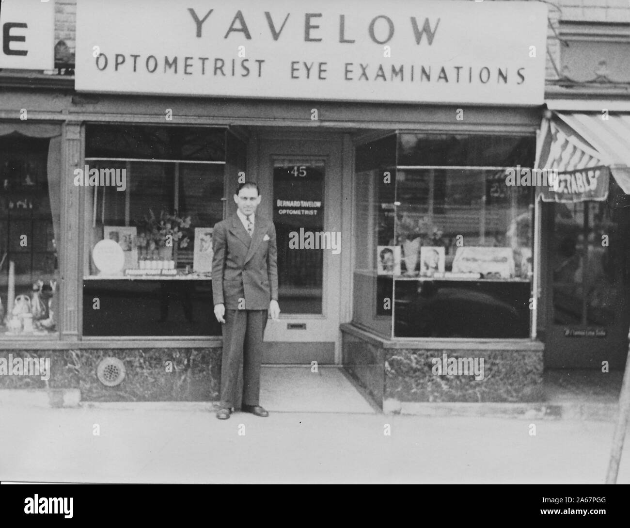 Bernard Yavelow, optométriste juif-américain, est fier de se présenter à l'extérieur de sa vitrine à New York City, New York, 1940. () Banque D'Images