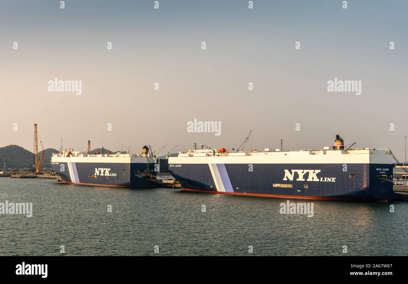 Port de Laem Chabang, Thaïlande - 17 mars 2019 : deux gros bleu-blanc NYKline, transporteurs de véhicules Polaris et leader métis, amarré sous les soleils bleu clair Banque D'Images
