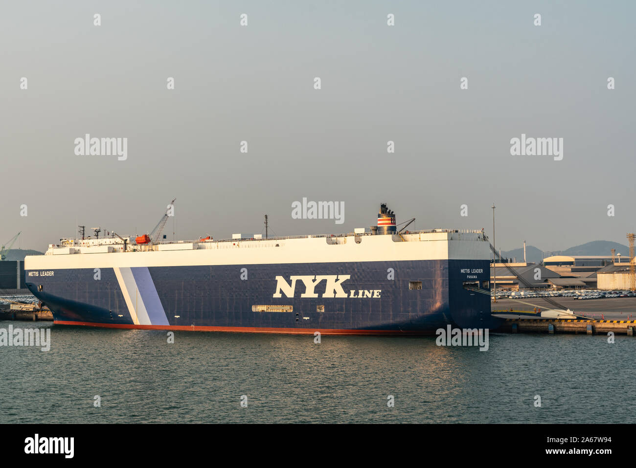 Port de Laem Chabang, Thaïlande - Mars 17, 2019 : Grand bleu-blanc NYKline véhicule transporteur, leader métis, a signalé au Panama, amarré sous lumière uv bleu Banque D'Images