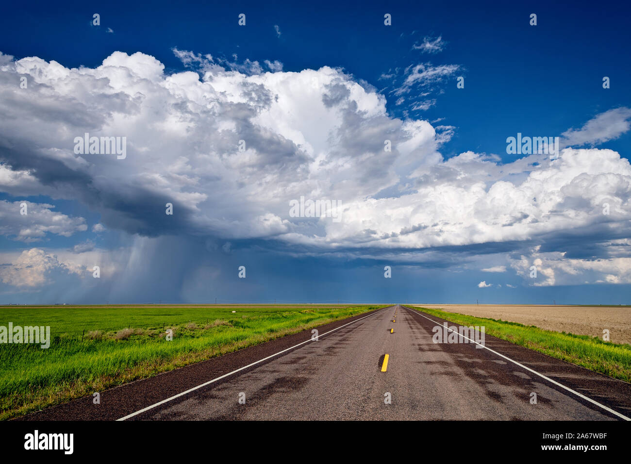 Une route droite mène vers un nuage de tempête de cumulonimbus à l'horizon près de St. Francis, Kansas Banque D'Images