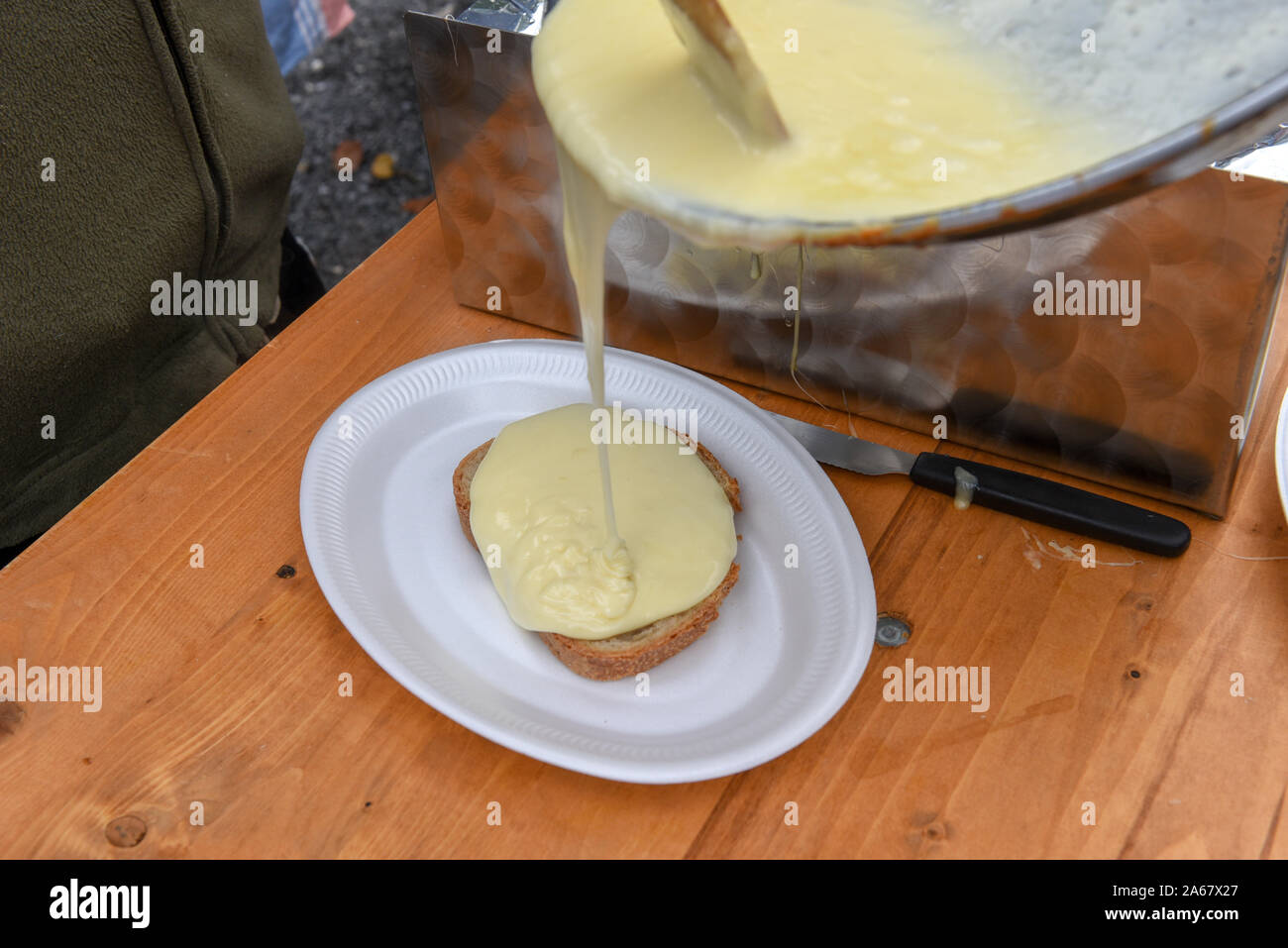 La préparation de fromage fondu traditionnel sur un pain sur les Alpes Suisses Banque D'Images