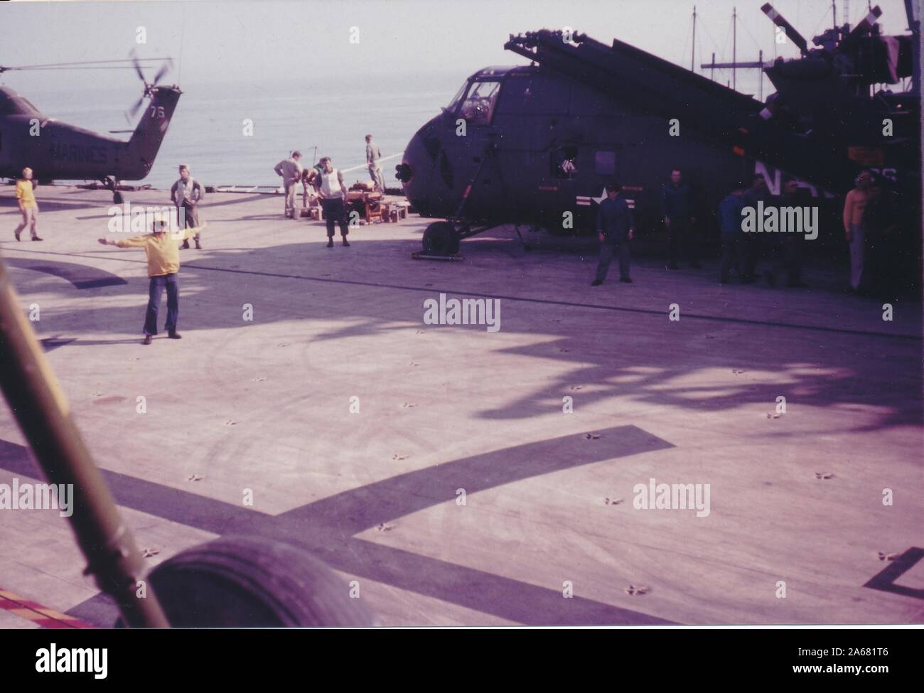 Tir légèrement à angle élevé d'hélicoptères et de serviceman américain sur le pont d'un porte-avions militaires, probablement photographié près de la côte du Vietnam, 1965. () Banque D'Images