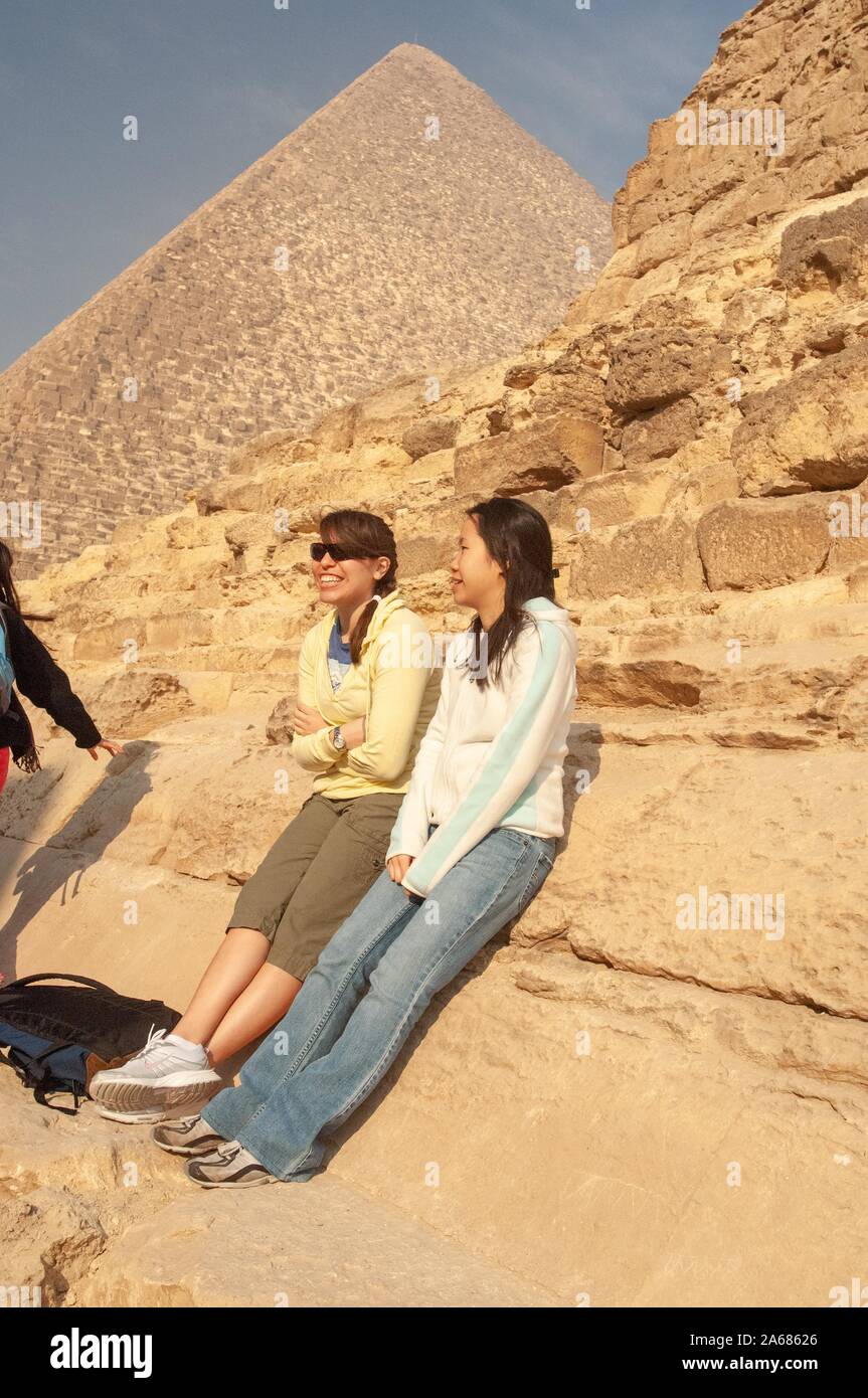 Deux étudiants de l'Université Johns Hopkins, à l'extérieur par une journée ensoleillée, s'appuyant sur la base d'une pyramide, avec une deuxième pyramide visible à l'arrière-plan, Giza, Egypte au cours d'un programme d'études à l'étranger, le 7 janvier 2008. À partir de la collection photographique de Homewood. () Banque D'Images