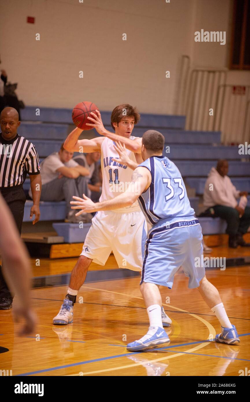 Un adversaire tente de bloquer une Université Johns Hopkins Men's Basketball player alors qu'il se prépare à passer le ballon à l'occasion d'un match avec Baruch College, le 3 janvier 2010. À partir de la collection photographique de Homewood. () Banque D'Images