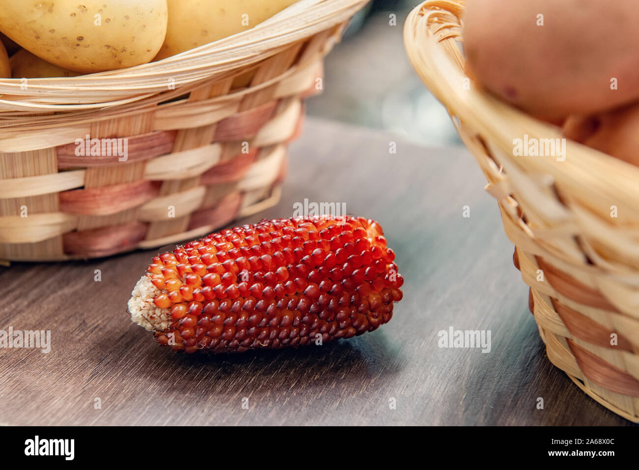 Une oreille de maïs rouge se trouve parmi les légumes sur le marché de l'agriculteur. Variétés et hybrides avancés Banque D'Images