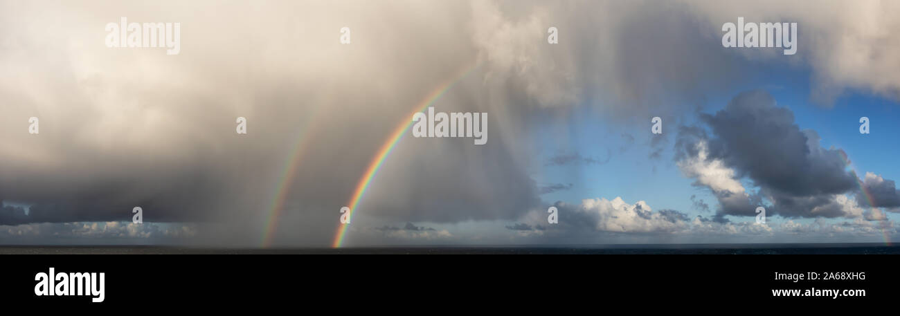 Vue panoramique spectaculaire d'une au cours d'une saison des pluies et cloudscape matin coloré avec un double arc-en-ciel lumineux. Prises au-dessus de l'océan Pacifique en Alaska, USA. Banque D'Images