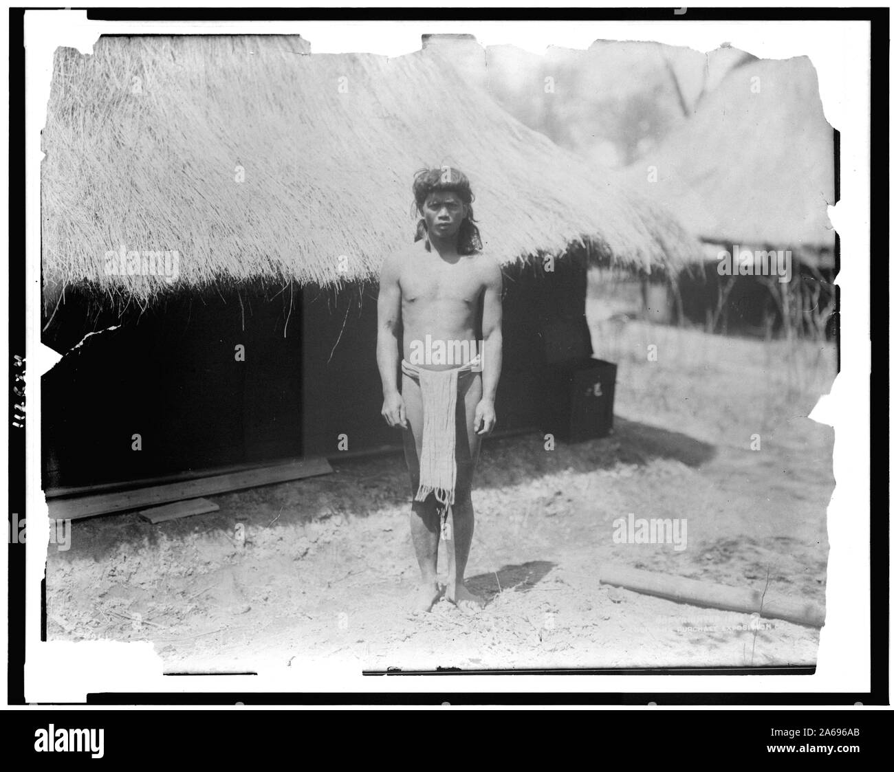 Jeune homme en vêtements traditionnels à côté de chaume en structure Igorot village, Louisiana Purchase Exposition Banque D'Images