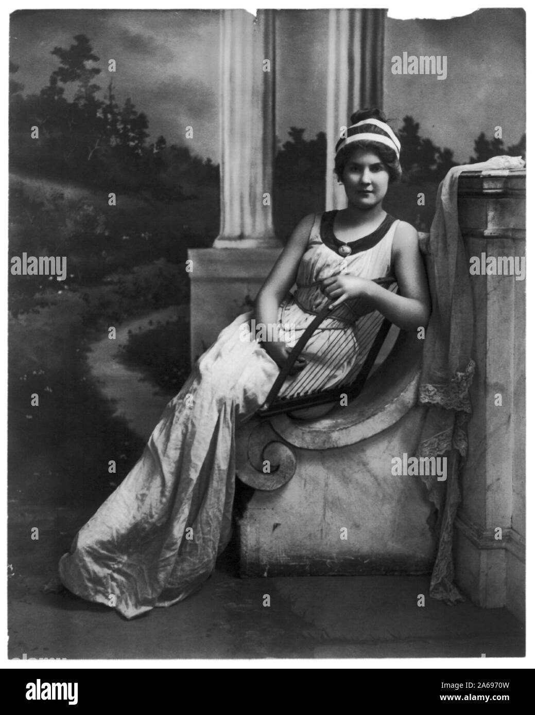 Les jeunes femmes : modélisation pleine longueur., assis, tenant la lyre Banque D'Images