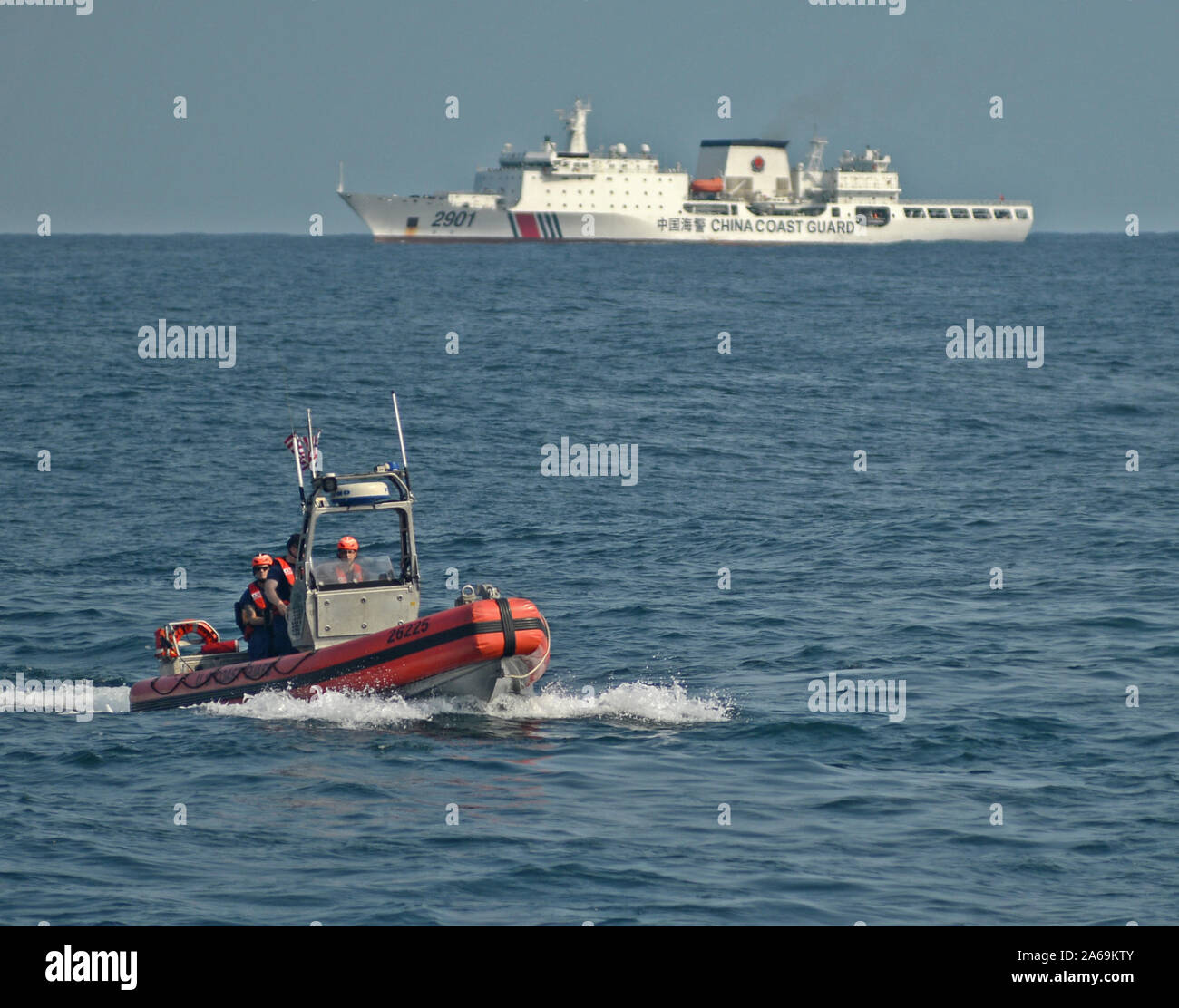 Un petit bateau de l'équipage de la Garde côtière canadienne Stratton mène des opérations dans la mer Jaune, le 6 octobre 2019, avec un garde-côte de la Chine à l'horizon. La Stratton était sur un Conseil de sécurité de l'ONU patrouille les relations dans le cadre de la United States' contribution continue aux efforts internationaux dans la lutte contre la République populaire démocratique de Corée (RPDC) sanctions maritime l'activité de fraude fiscale. U.S. Coast Guard photo de PA1 Nate Littlejohn Banque D'Images