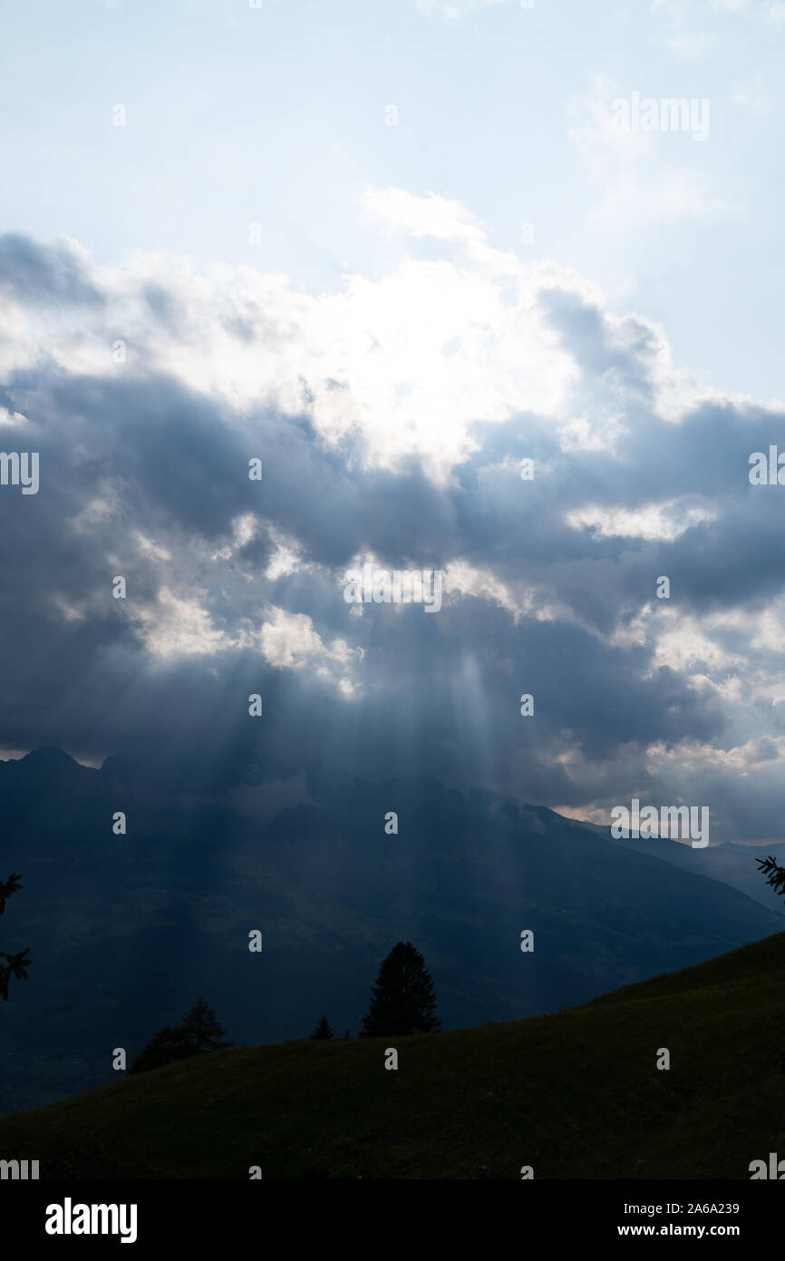 Les rayons du soleil qui brille à travers les nuages dans les montagnes Banque D'Images