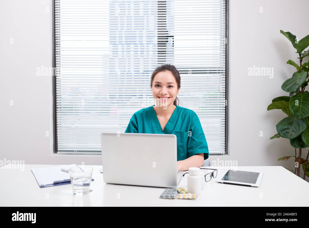 Jeune femme médecin au travail tout en tapant sur un ordinateur portable à l'hôpital. Banque D'Images