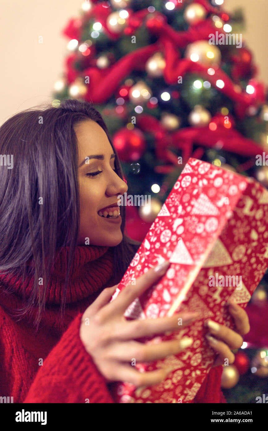 Happy girl with christmas present.Smiling woman enjoying Xmas. Banque D'Images