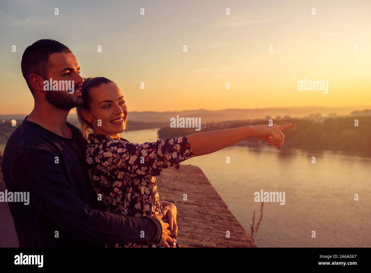 Aimer l'homme et la femme en regardant le coucher du soleil Banque D'Images