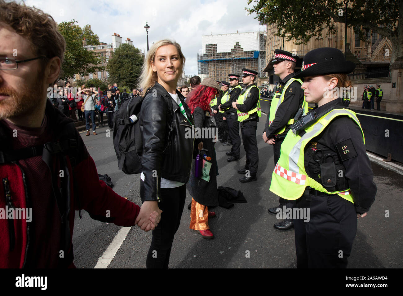 Extinction des militants changement climatique rébellion tenir la main dans une ligne face à une rangée de policiers comme sites autour de Westminster sont bloqués le 8 octobre 2019 à Londres, Angleterre, Royaume-Uni. Rébellion d'extinction est un groupe climatique a commencé en 2018 et a acquis une énorme de personnes engagées à la suite de manifestations pacifiques. Ces manifestations sont en soulignant que le gouvernement ne fait pas assez pour éviter un changement climatique catastrophique et à la demande au gouvernement de prendre des mesures radicales pour sauver la planète. Banque D'Images