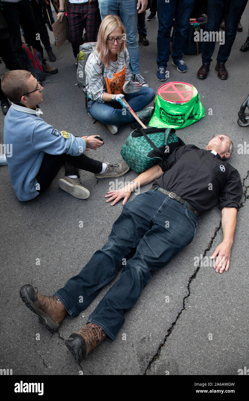 Rébellion d'extinction les changements climatiques et d'activistes se couche à Whitehall prêtre d'attendre d'être arrêté par la police en tant que sites autour de Westminster sont bloqués le 8 octobre 2019 à Londres, Angleterre, Royaume-Uni. Rébellion d'extinction est un groupe climatique a commencé en 2018 et a acquis une énorme de personnes engagées à la suite de manifestations pacifiques. Ces manifestations sont en soulignant que le gouvernement ne fait pas assez pour éviter un changement climatique catastrophique et à la demande au gouvernement de prendre des mesures radicales pour sauver la planète. Banque D'Images