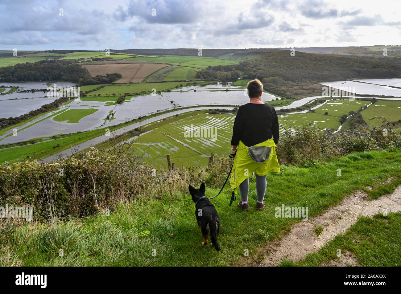 Alfriston Sussex UK 25 octobre 2019 - Un chien walker donne sur les inondations le long de la rivière Cuckmere près de 1 156 km dans l'East Sussex après des semaines de forte pluie qui a été au-dessus de la moyenne pour la période de l'année. Météo jaune avertissements ont été émis pour les régions du pays où plus de fortes pluies et des inondations est prévue au cours des prochaines 24 heures . Les inondations le long de la Cuckmere Haven a été pire dans les cours des dernières années, depuis que l'Agence de l'environnement a décidé d'arrêter l'entretien des défenses. Crédit : Simon Dack / Alamy Live News Banque D'Images