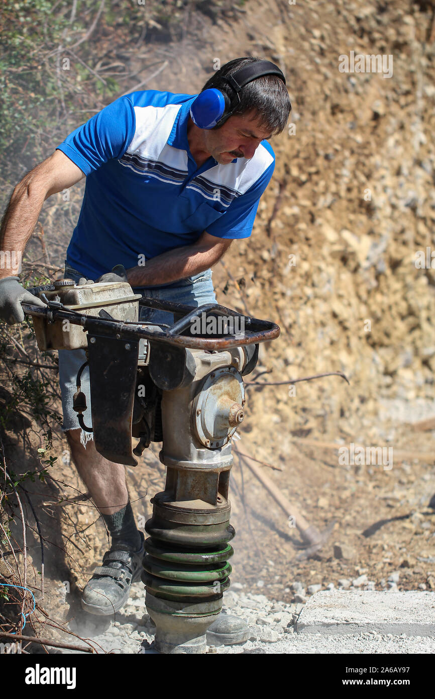 Construction Worker tasser la terre à l'aide de compacteur. Travailler avec la  machine de damage Photo Stock - Alamy