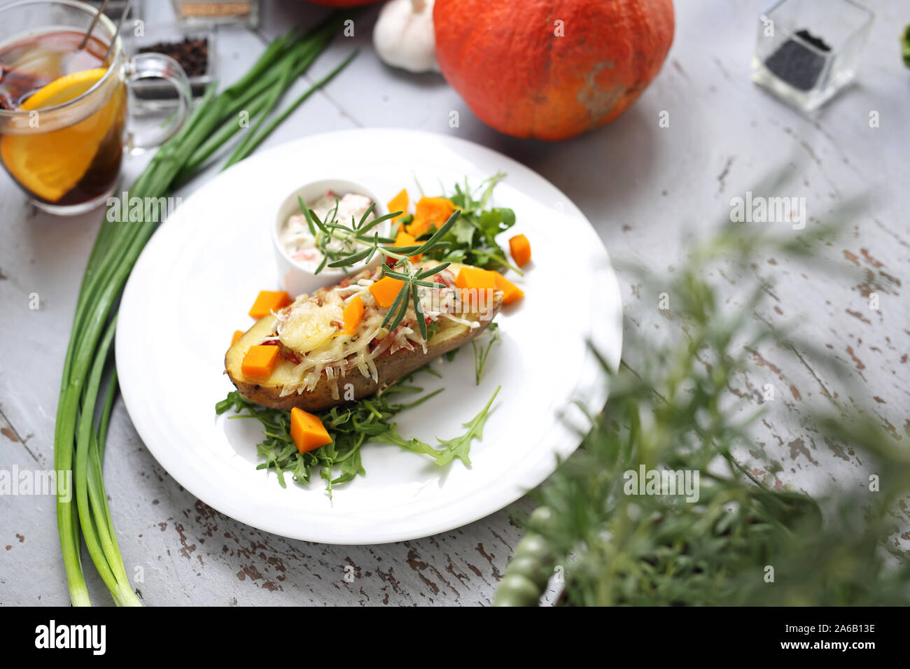 Pomme de terre farcies de fromage jaune, ciboulette, beurre, citrouille et mariné avec sauce romarin frais Banque D'Images