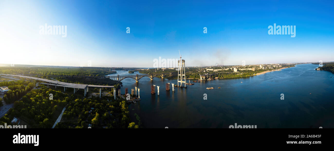 Vue panoramique aérienne du pont automobile incomplète et Arch Bridge en arrière-plan de station d'énergie hydroélectrique. Ville industrielle. Banque D'Images