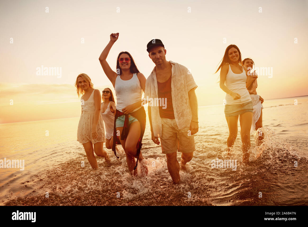 Groupe de jeunes amis s'amusent à sunset beach party Banque D'Images