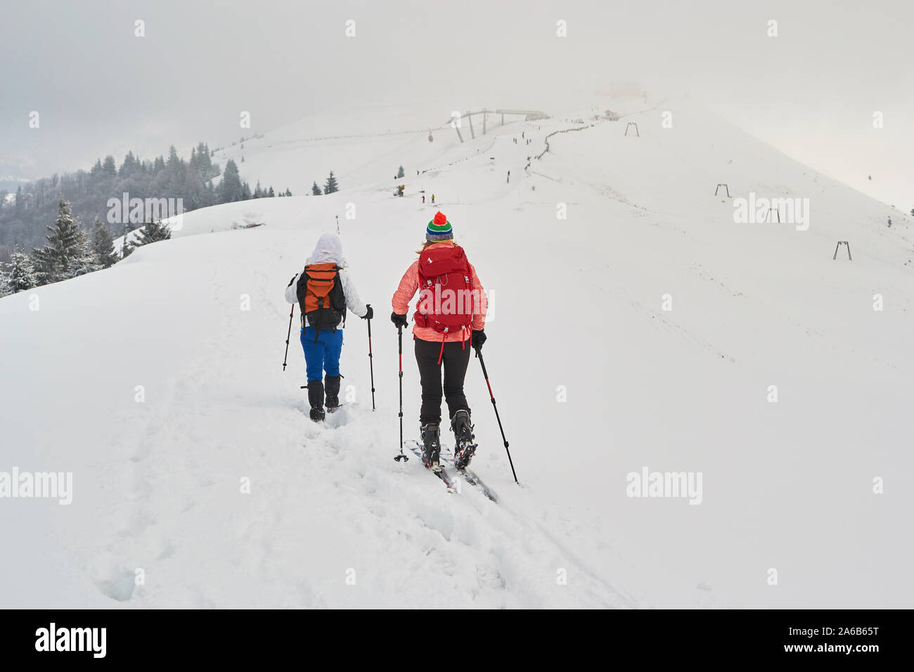 Deux femmes les amis de la randonnée et le ski de randonnée côte à côte sur une crête, avec ciel couvert, au-dessus de la station de ski de Azuga, Vallée de Prahova, montagnes Baiului, romani Banque D'Images