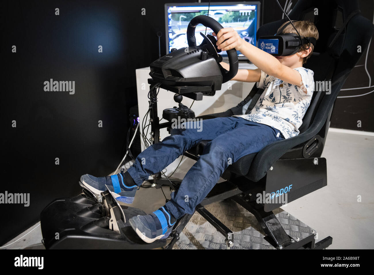 BRATISLAVA, SLOVAQUIE - OCT 25, 2019 : Jeune garçon sillonnant sur jeu de course 2DOF motion simulator avec lunettes de réalité virtuelle au centre commercial à Bratislava, Slo Banque D'Images