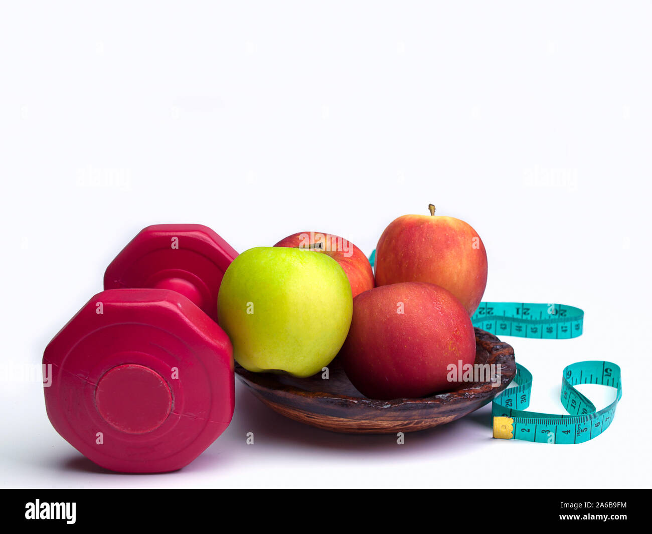 Haltères rouge avec bande de mesure de poids et régime alimentaire pour apple concept sur fond blanc Banque D'Images