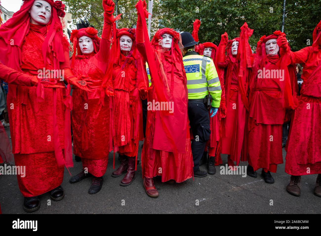 Londres, 10 octobre 2019, l'extinction en costumes rouge groupe rébellion police surround préparation de l'arrestation qui acivists ont enfermés pour une structure en bois dans la route à côté de Trafalgar Square. Banque D'Images