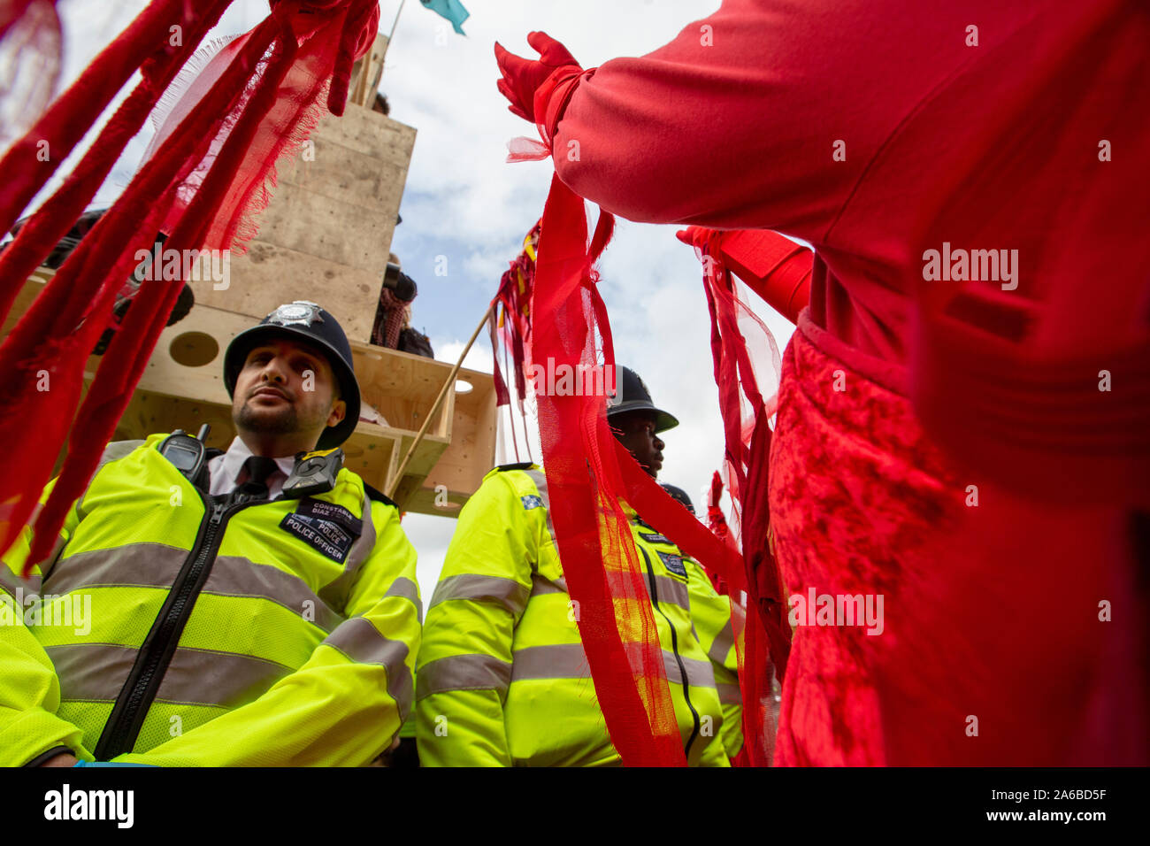 Londres, 10 octobre 2019, l'extinction en costumes rouge groupe rébellion police surround préparation de l'arrestation qui acivists ont enfermés pour une structure en bois dans la route à côté de Trafalgar Square. Banque D'Images