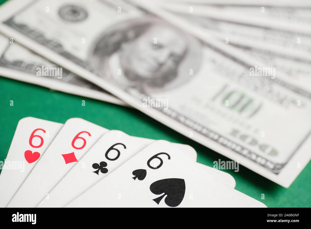 Close up de combinaison de quatre des six au cours de poker sur fond de dollar bills sur le tableau vert. Banque D'Images