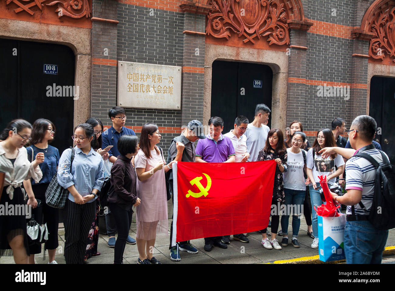 Drapeau chinois avec les travailleurs en dehors de l'emplacement de l'Premier Congrès National du Parti communiste chinois Xintiandi, Xingye sur Road Banque D'Images