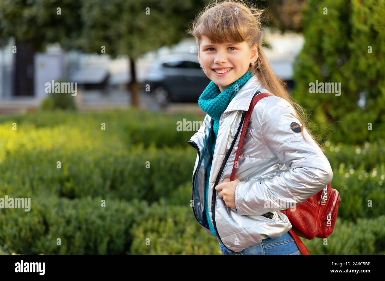 Heureux lycéenne 9-10 ans dans une veste et avec un sac à dos. Girl aller à l'école. Banque D'Images