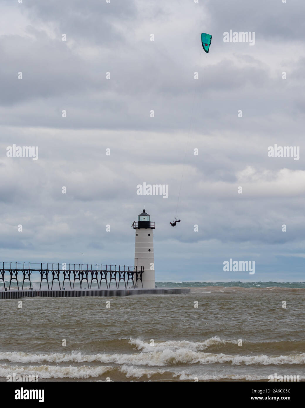 Un kite surfer flies high en face de l'Amérique du Manistee Pierhead Phare dans le Michigan, USA. Banque D'Images