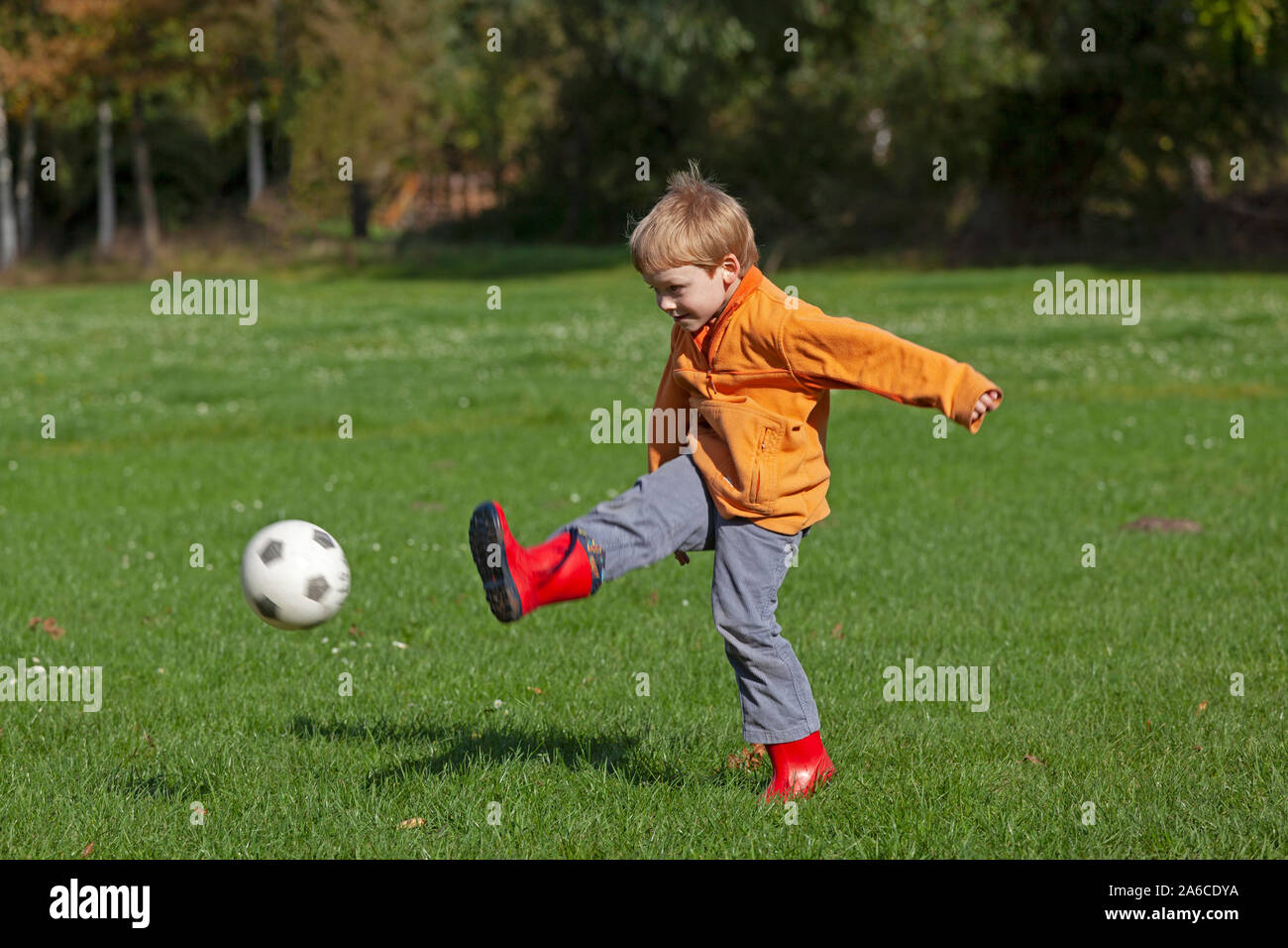 Un petit garçon joue au football. Banque D'Images