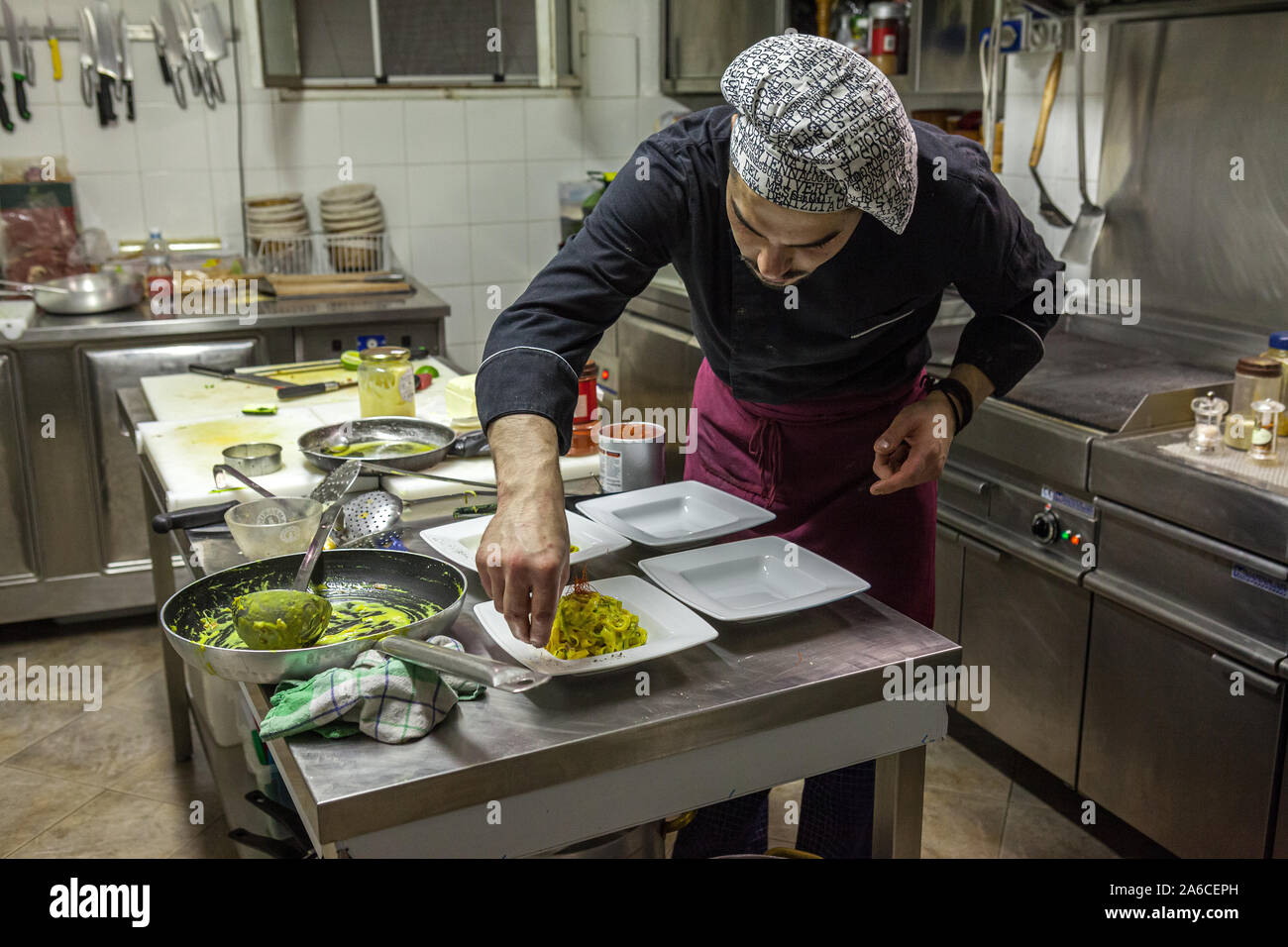 Jeune chef italien et cuisine un plat de pâtes de décoration. Italie Banque D'Images