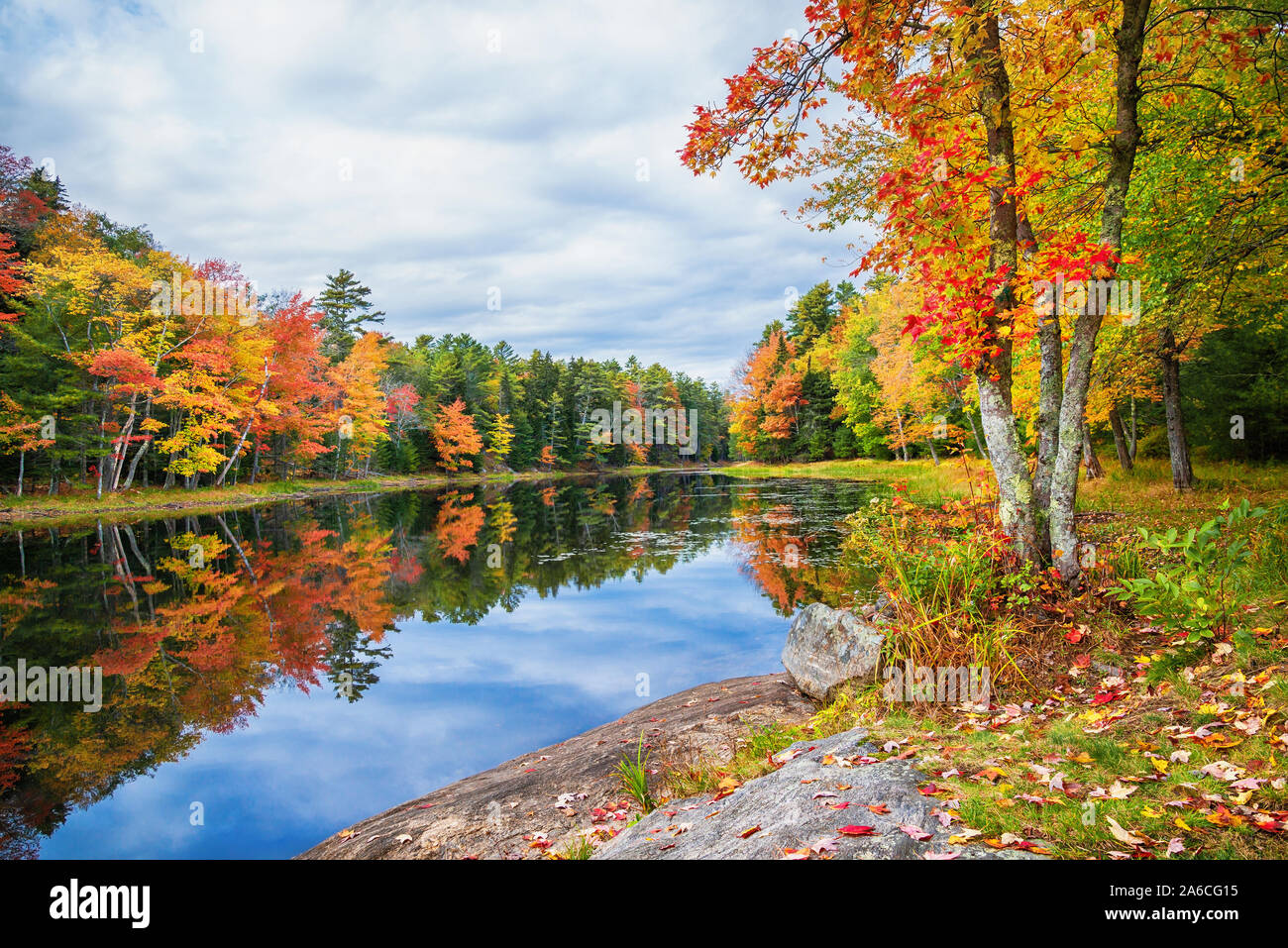 Les couleurs de l'automne reflète dans l'eau du lac encore sur une belle journée d'automne en Nouvelle Angleterre Banque D'Images