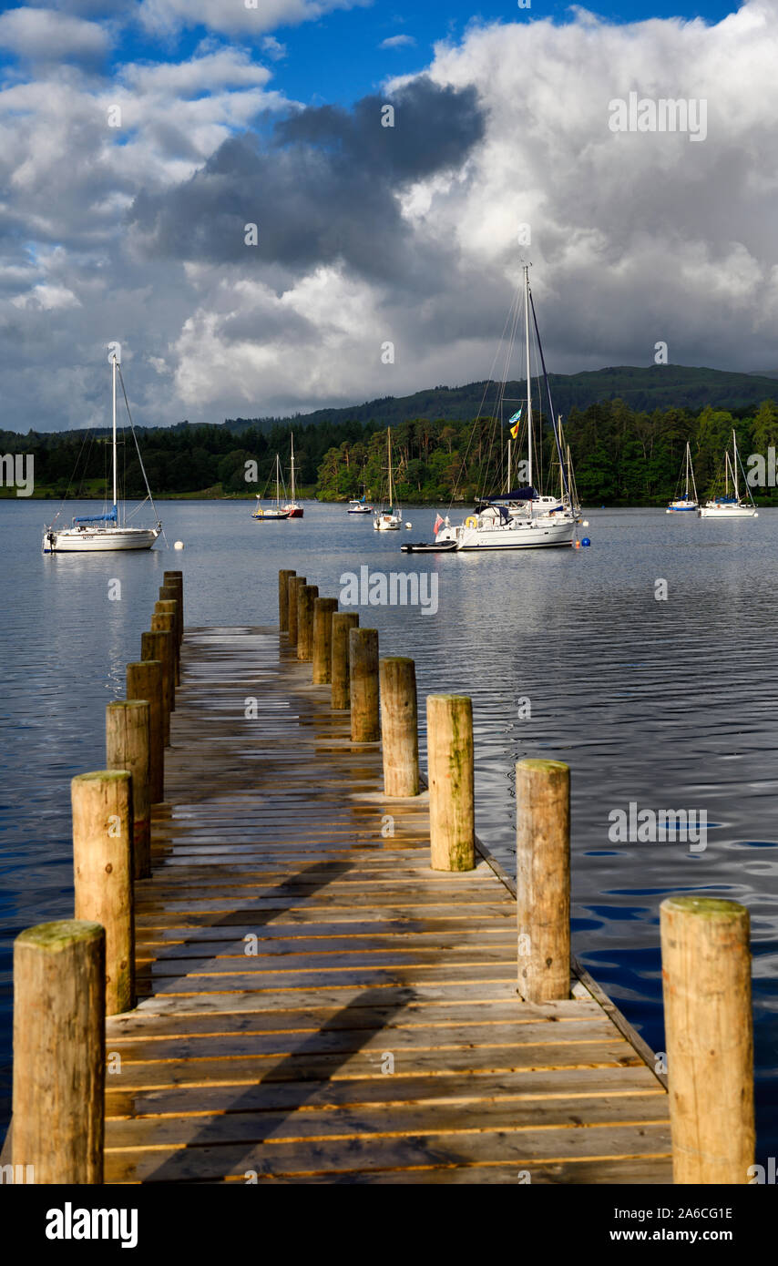 La lumière du soleil du matin sur la jetée en bois menant à la location voiliers sur le lac Windermere Ambleside Cumbria England à Waterhead Banque D'Images