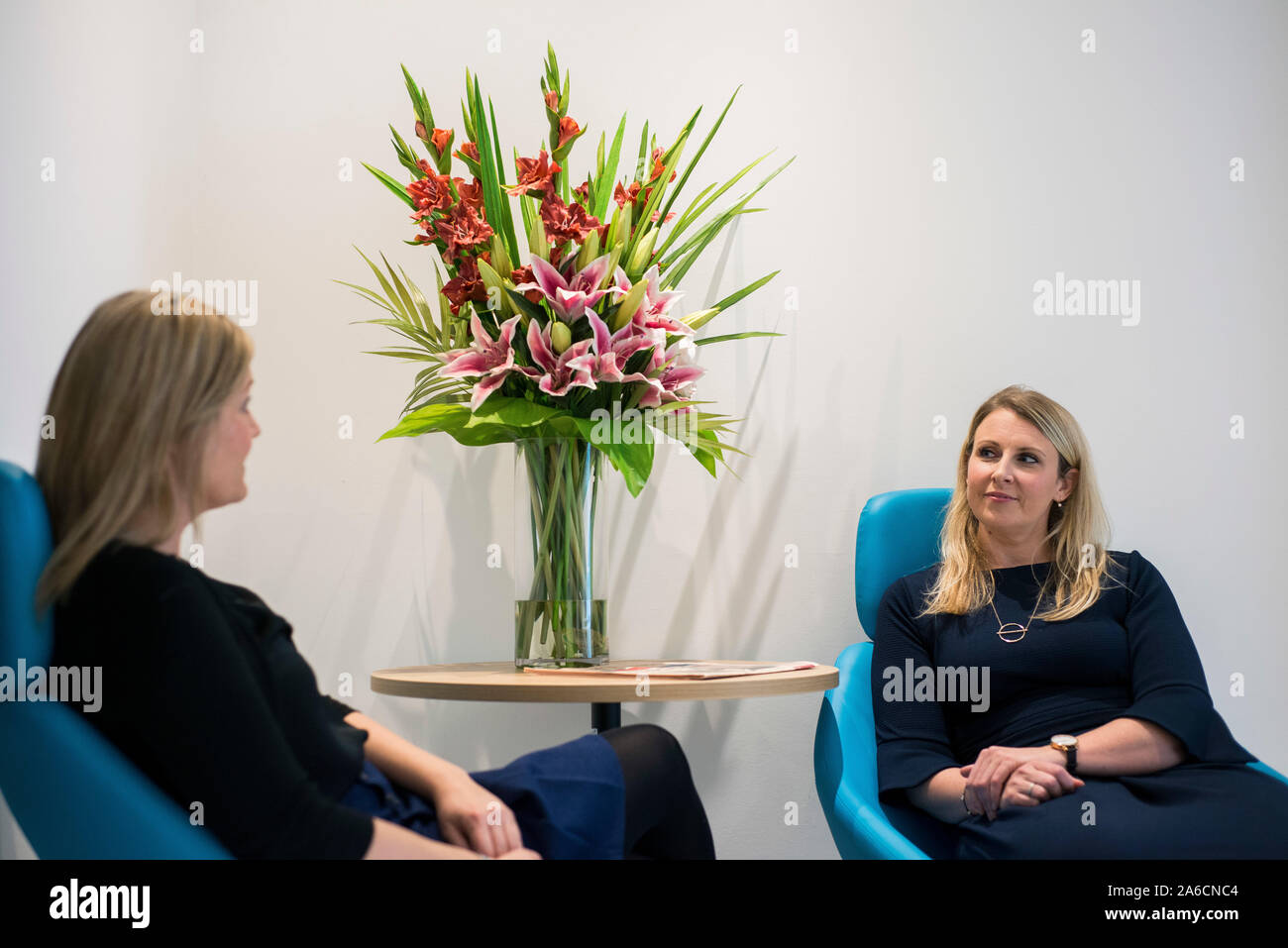 Deux femmes assises dans de grandes chaises dans un environnement de bureau moderne Banque D'Images