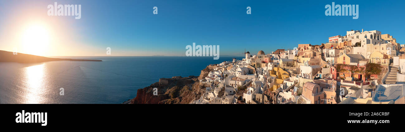 Coucher de soleil sur l'île de Santorin en Grèce. L'église traditionnelle, les appartements et les moulins à vent à Oia village sur une image panoramique, coucher du soleil Banque D'Images