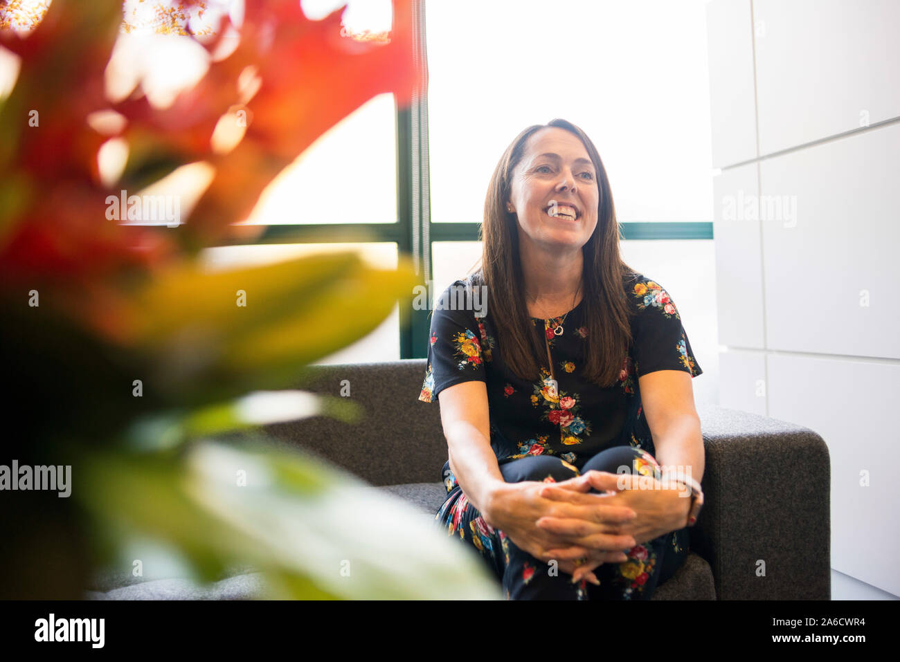 Une femme employée de bureau est assis sur un canapé dans le bureau moderne Banque D'Images