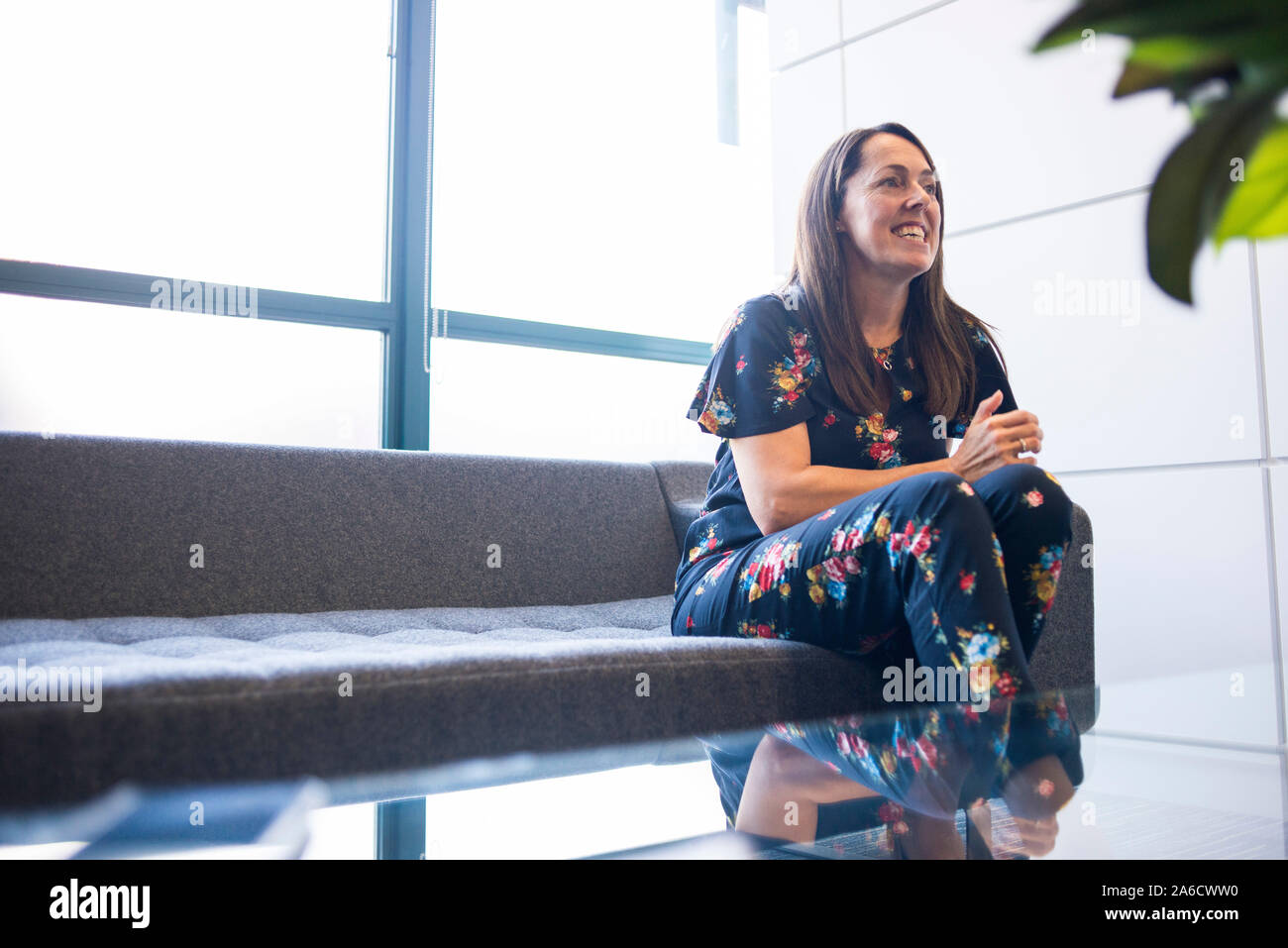 Une femme employée de bureau est assis sur un canapé dans le bureau moderne Banque D'Images