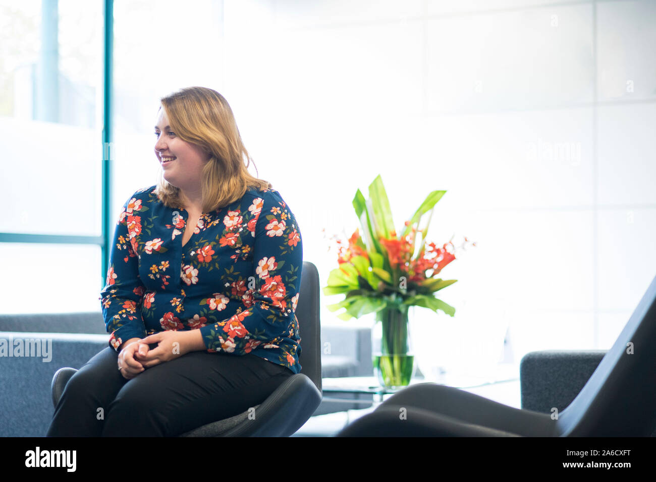 Une femme employée de bureau est assis sur un canapé dans le bureau moderne Banque D'Images