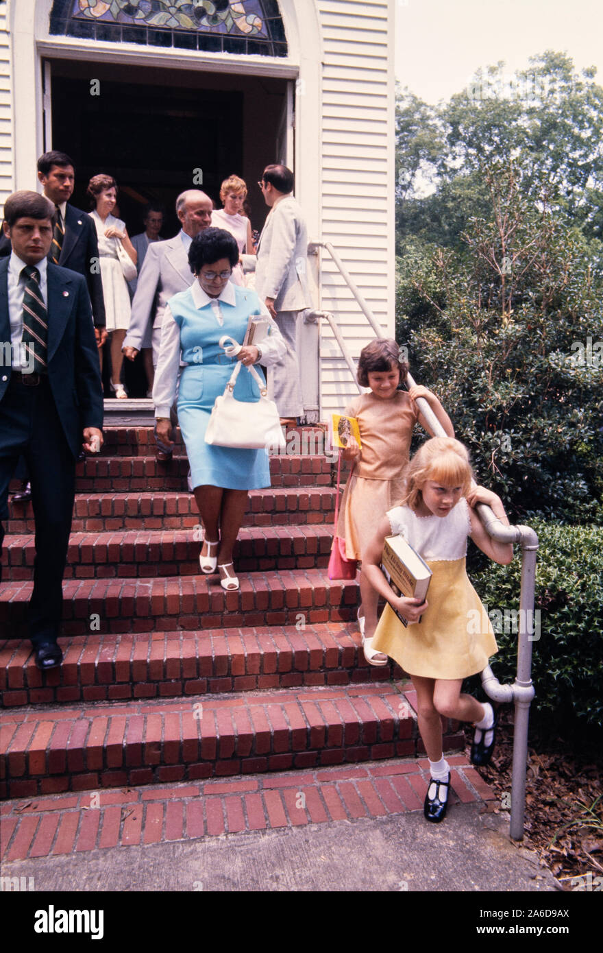 Amy carter - en robe jaune - fille du président Jimmy carter, est éclipsée par un agent du service secret alors qu'elle quitte les services du dimanche à l'église baptiste des plaines, en Géorgie. Banque D'Images