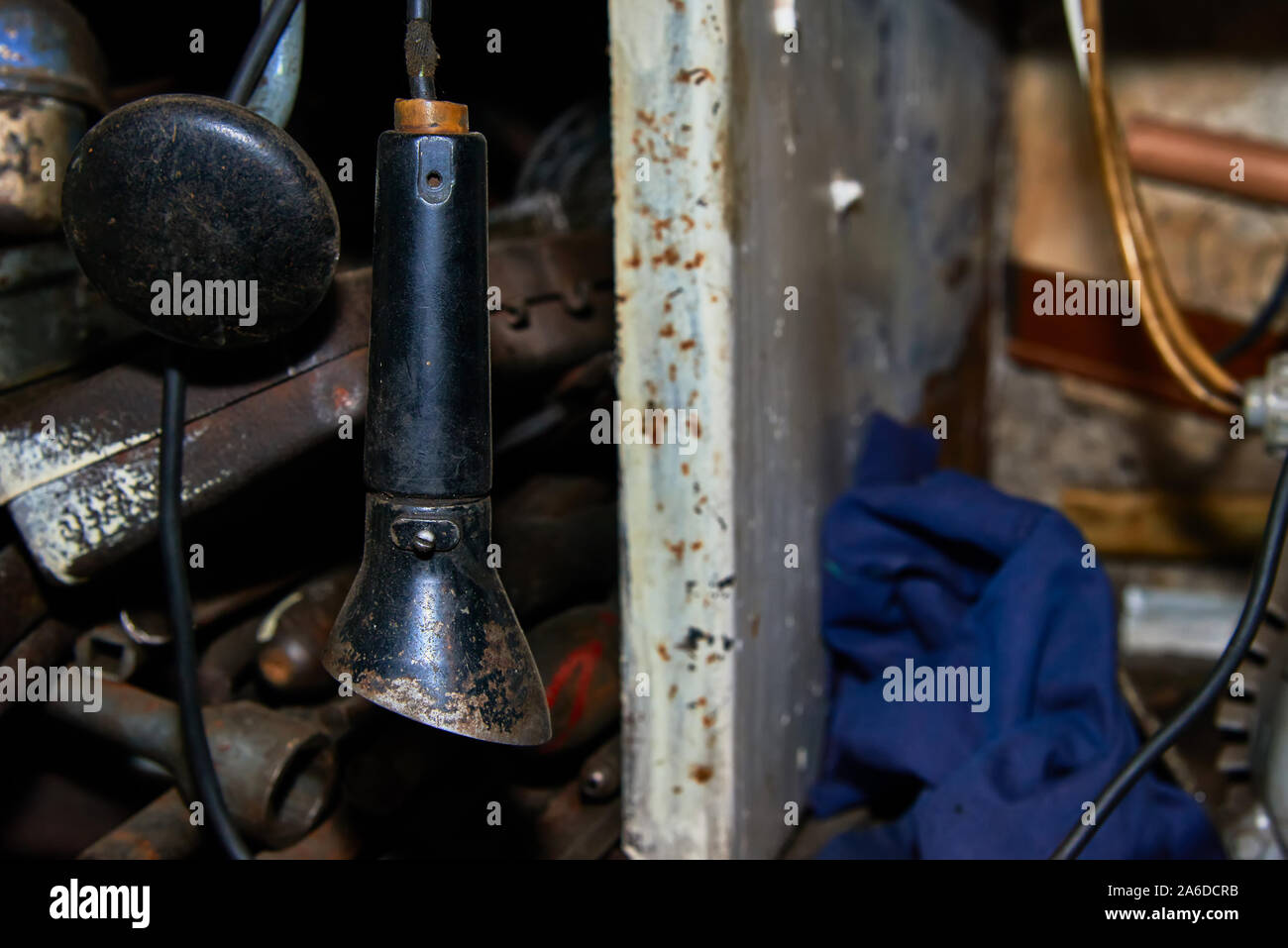 Vieille lampe rouillée près du câblé avec des outils rack dans le garage libre Banque D'Images