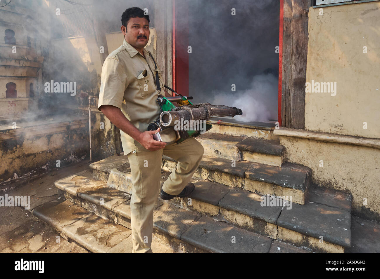 Avant le début de la mousson, un employé de la Brihanmumbai Municipal Corporation pulvérise un insecticide pour lutter contre la peste des moustiques; Mumbai, Inde Banque D'Images