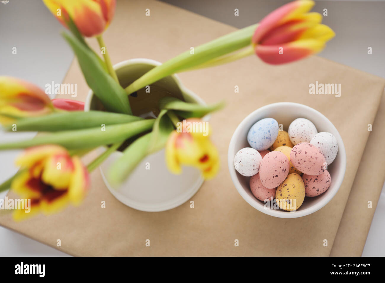 Bonbons de Pâques oeuf sur le flou artistique avec bouquet de tulipes Banque D'Images