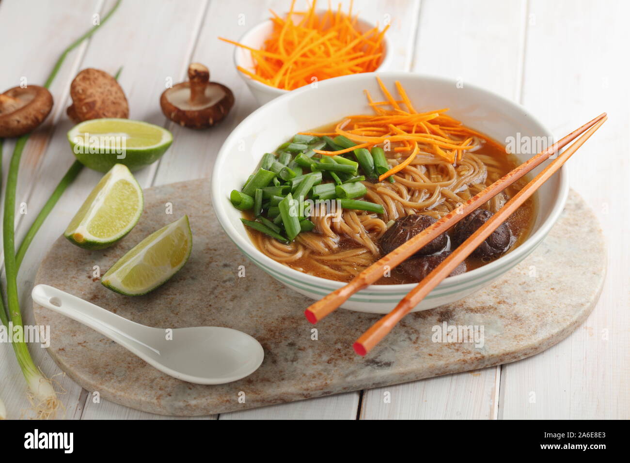 Les champignons shiitake et soupe de nouilles soba avec carotte, oignon vert, et lime Banque D'Images