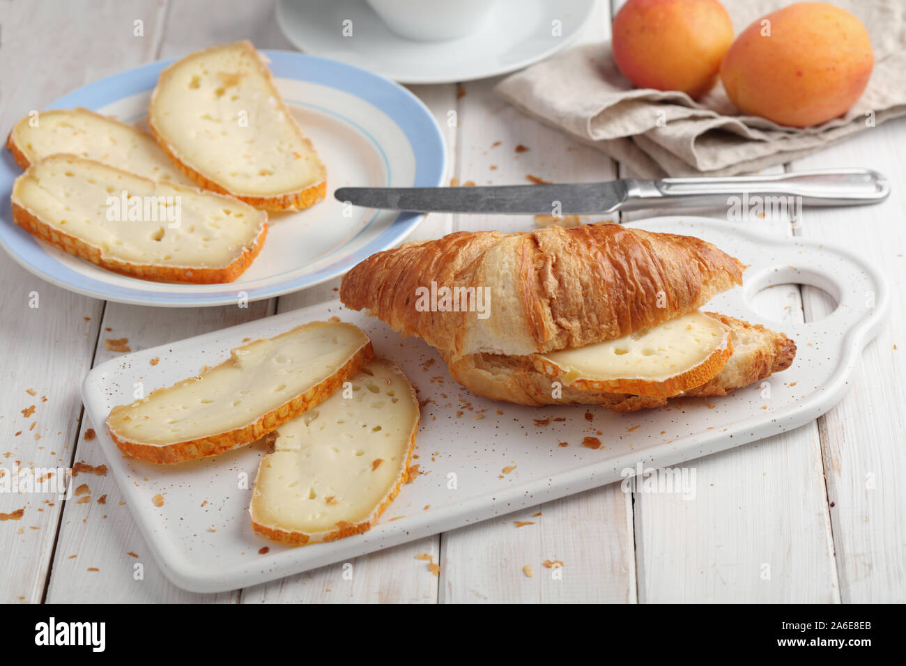 Croissant sandwich avec fromages tranchés sur une table rustique Banque D'Images